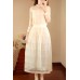 فستان أنيق بتصميم عصري باللون الأبيض ذات أكمام طويلة ورقبة دائرية